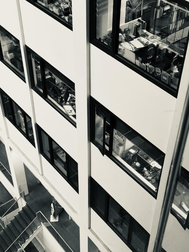 Modern office building atrium viewed from above, with professionals working inside