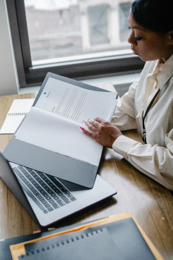 Professional reviewing employment documents and records at a desk